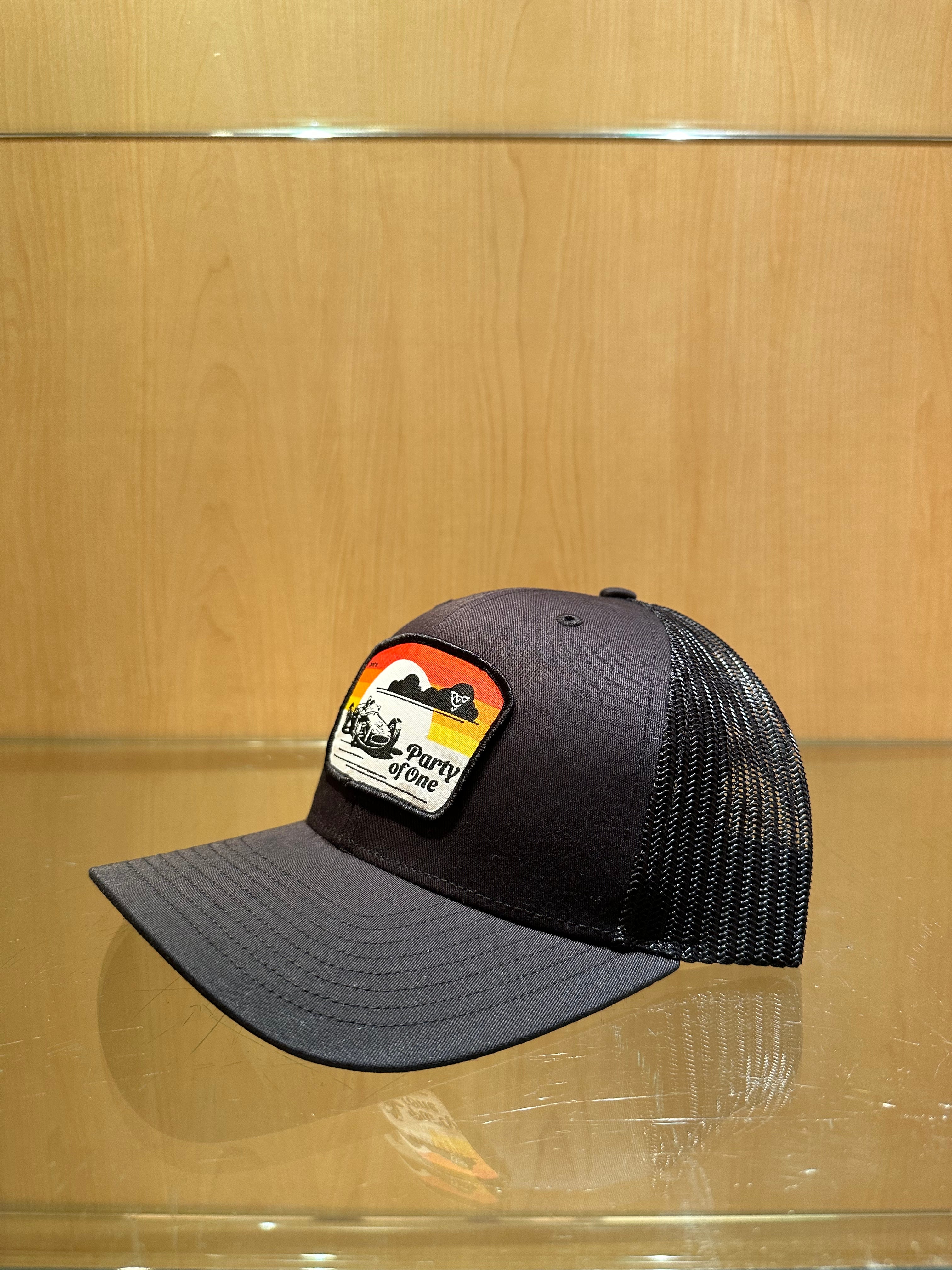 PARTY OF ONE (Black/Black Premium Trucker Hat)