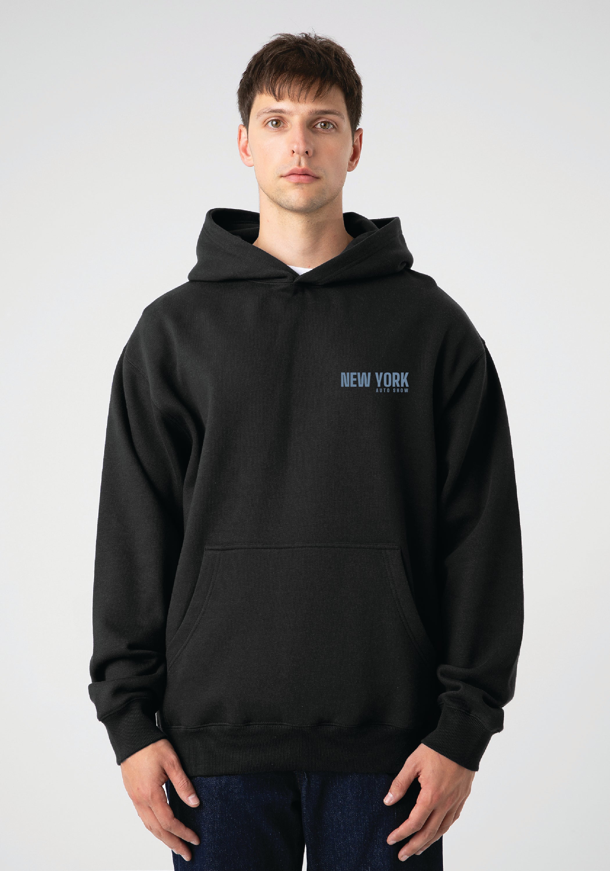 Person wearing a black hoodie with 'New York' text on a plain background
